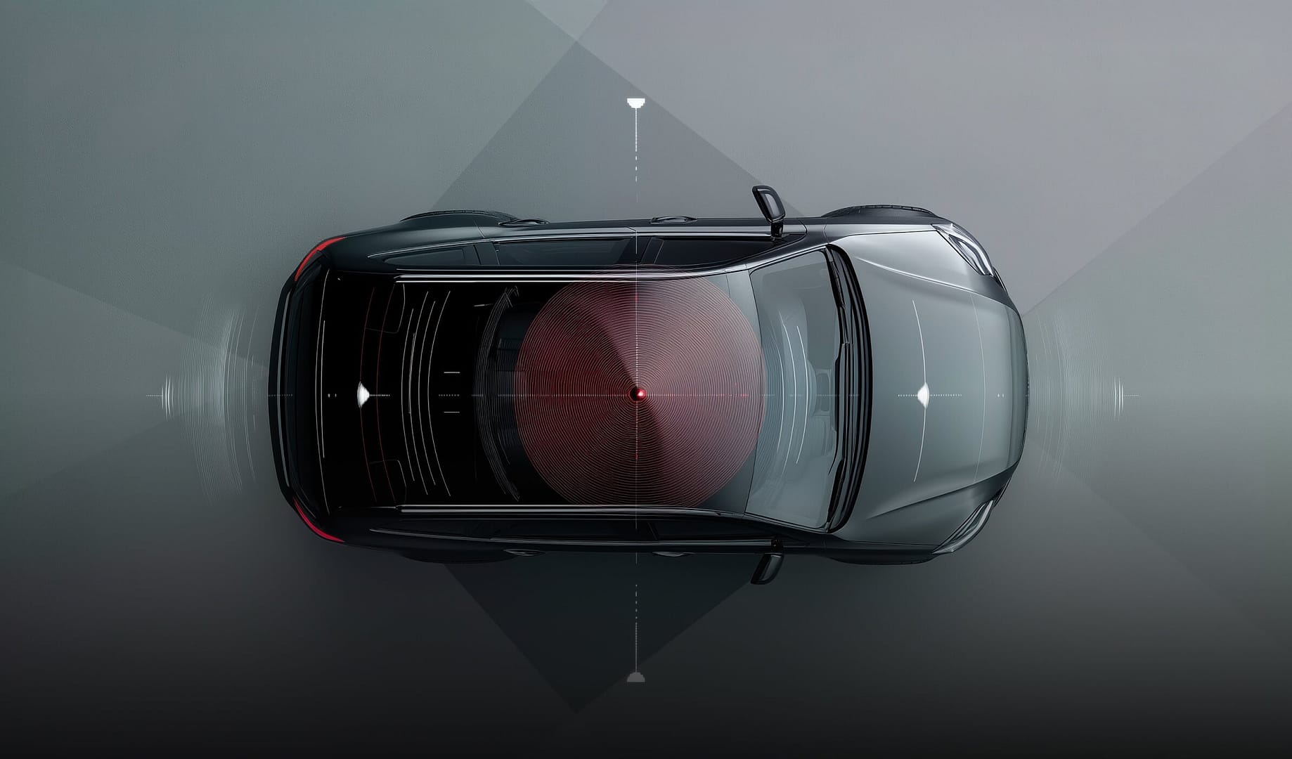 Overhead view of a black car on a gray background with radar-like graphics indicating sensor or detection fields around the vehicle, highlighting technology for navigation or safety systems.