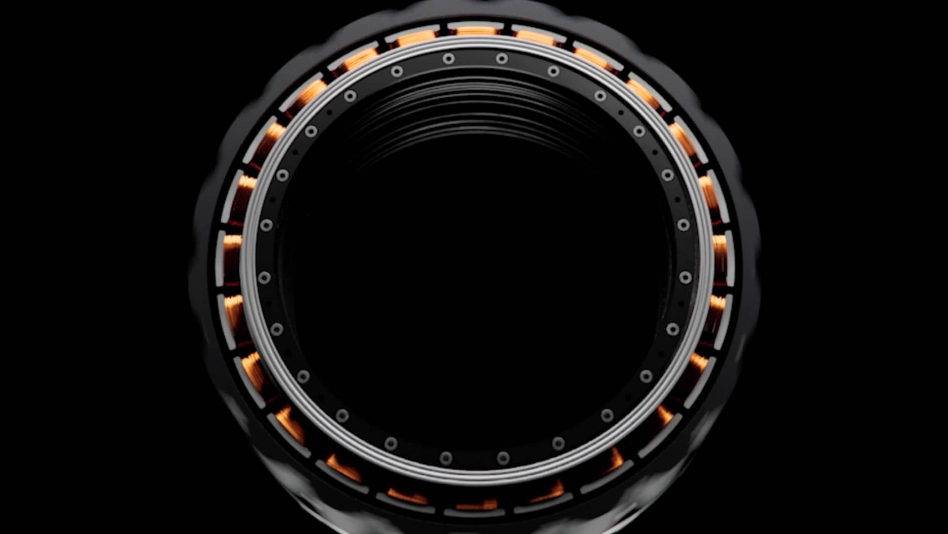 about-us A close-up of a circular mechanical component with a black center and intricate details. Orange elements and several small screws or bolts are evenly spaced around its circumference, resembling a lens or turbine. The background is entirely black.
