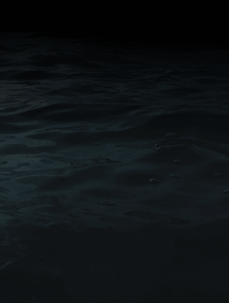A dark, mysterious body of water with gentle ripples and subtle reflections under a dim light, creating a tranquil yet enigmatic atmosphere. The surface appears calm, and the background fades into black.