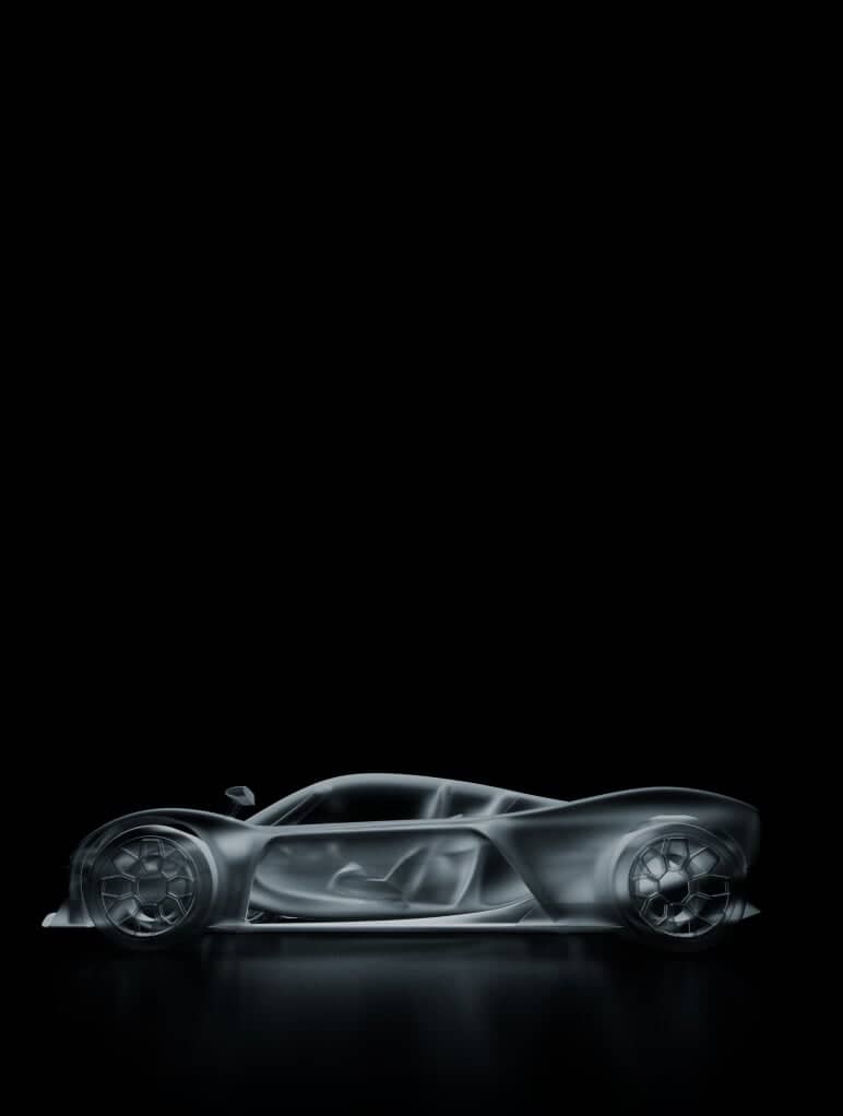 An X-ray view of a sports car on a black background, showing internal structures and components in transparent detail. The image highlights the sleek design and engineering aspects of the car.